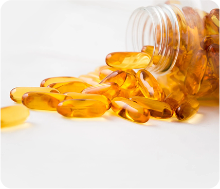 An image of orange pills spilled against a white Background